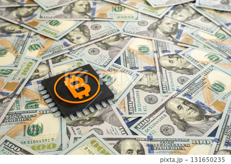 A Bitcoin chip against a backdrop of dollars. Profits from cryptocurrency mining and trading. Digital economy, blockchain finance, crypto investment, and market volatility. 131650235
