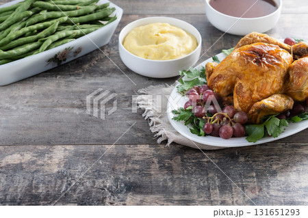 Thanksgiving roasted turkey with mashed potatoes, cranberry sauce and green beans on rustic wooden table Thanksgiving roasted turkey with mashed potatoes, cranberry sauce and green beans on rustic wooden table 131651293