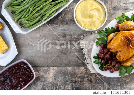 Thanksgiving roasted turkey with mashed potatoes, cranberry sauce and green beans on rustic wooden table Thanksgiving roasted turkey with mashed potatoes, cranberry sauce and green beans on rustic wooden table 131651303