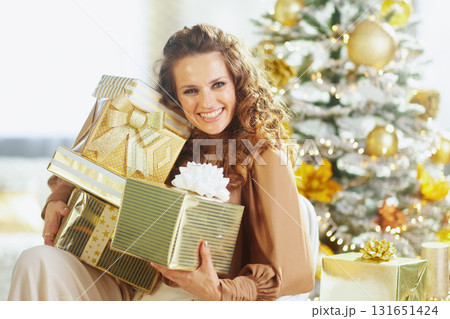 Smiling Woman with Gold Green Christmas Gifts Smiling Woman with Gold Green Christmas Gifts 131651424