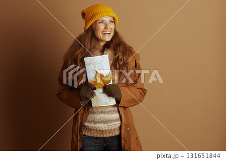 Pensive Autumn Traveler with Map and Leaf 131651844
