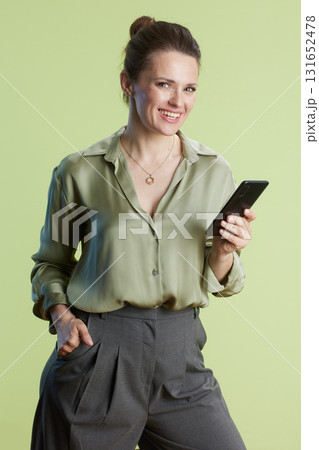 Smiling professional with smartphone in hand Smiling professional with smartphone in hand 131652478