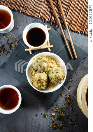 Stylish black stone textured background setup, top down view capturing traditional Hong Kong dim sum beef balls at a local teahouse Stylish black stone textured background setup, top down view capturing traditional Hong Kong dim sum beef balls at a local teahouse 131652679