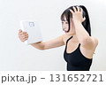 体重計を持ち頭を抱える女性　体を鍛えてるかっこいい女性　ダイエット　白バック　 131652721