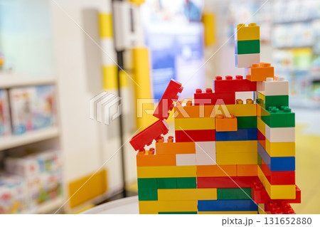 A vibrant structure built from colorful plastic constructor blocks stands on display in a toy store. Bright colors and soft focus in the background create a cheerful and playful atmosphere. 131652880