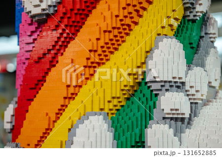 A detailed close-up of a sculpture shows bright rainbow stripes and fluffy white clouds built from colorful bricks. The texture and craftsmanship of the construction are clearly visible. 131652885