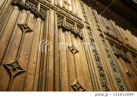 This detailed photo shows the textured bronze door of St. Patrick's Cathedral in New York City. The design features pointed Gothic elements and intricate floral engravings. This detailed photo shows the textured bronze door of St. Patrick's Cathedral in New York City. The design features pointed Gothic elements and intricate floral engravings. 131652894