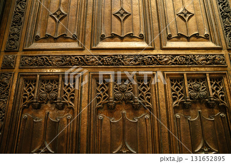 The photo captures a close-up of an ornate bronze door at St. Patrick's Cathedral in New York City. Intricate floral and vine carvings highlight the craftsmanship and Gothic style of this historic The photo captures a close-up of an ornate bronze door at St. Patrick's Cathedral in New York City. Intricate floral and vine carvings highlight the craftsmanship and Gothic style of this historic 131652895