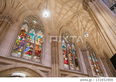 The image displays vibrant stained glass windows depicting biblical scenes inside a Gothic cathedral. The tall stone columns and vaulted ceiling enhance the spiritual and architectural beauty of the 131652900