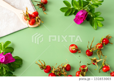 Top view of ripe rose hips on a green background 131653003