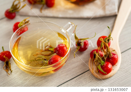 Medicinal rosehip tea in a cup on a wooden table Medicinal rosehip tea in a cup on a wooden table 131653007