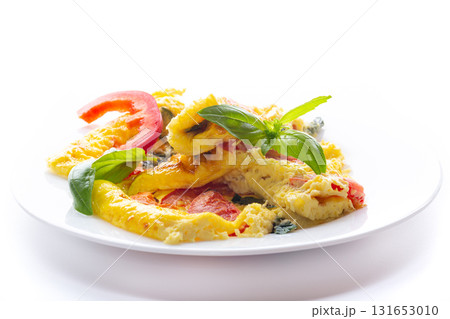 Fried omelette with vegetables and herbs on a white background 131653010
