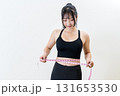 メジャーでウエストを測る女性　体を鍛えてるかっこいい女性　ダイエット　白バック 131653530