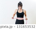 メジャーでウエストを測る女性　体を鍛えてるかっこいい女性　ダイエット　白バック 131653532