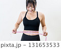 メジャーでウエストを測る女性　体を鍛えてるかっこいい女性　ダイエット　白バック　トリミングアップ 131653533
