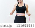 メジャーでウエストを測る女性　体を鍛えてるかっこいい女性　ダイエット　白バック 131653534