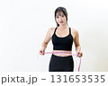 メジャーでウエストを測る女性　体を鍛えてるかっこいい女性　ダイエット　白バック 131653535