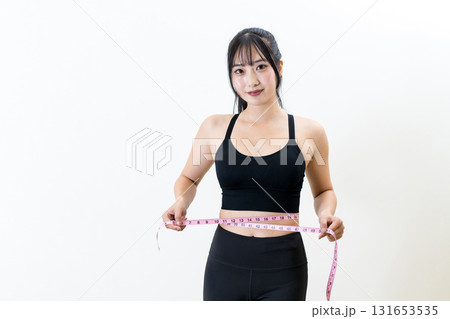 メジャーでウエストを測る女性 体を鍛えてるかっこいい女性 ダイエット 白バック メジャーでウエストを測る女性 体を鍛えてるかっこいい女性 ダイエット 白バック 131653535