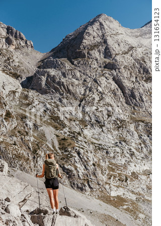 Woman Hiking Alone in Alpine Mountain Landscape Woman Hiking Alone in Alpine Mountain Landscape 131654123