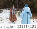 Woman bloggers enjoying a winter day while taking photos in a snowy forest 131654181