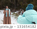 Winter bloggers recording video and capturing memories in a snowy forest setting 131654182
