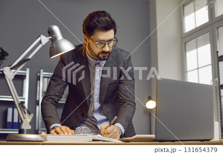 Handsome busy businessman working on some project in modern office 131654379