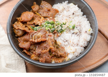 Jeyukdeopbap, Korean Food Spicy Stir-fried Pork with Rice in Black Bowl Jeyukdeopbap, Korean Food Spicy Stir-fried Pork with Rice in Black Bowl 131654487