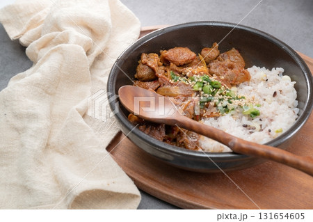 Jeyukdeopbap, Korean Food Spicy Stir-fried Pork with Rice in Black Bowl  131654605