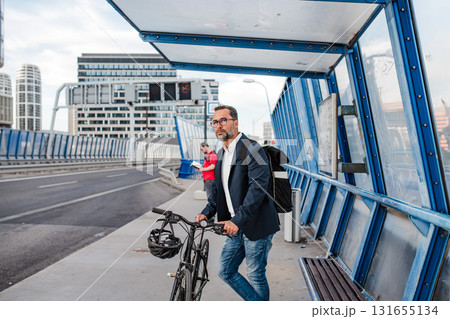 Cyclist waiting for city bus with bicycle. 131655134