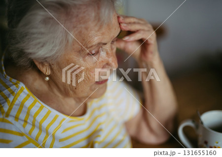 Portrait of worried senior woman crying in kitchen. 131655160