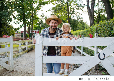 Little boy and father on farm, standing on fence. Little boy and father on farm, standing on fence. 131655181