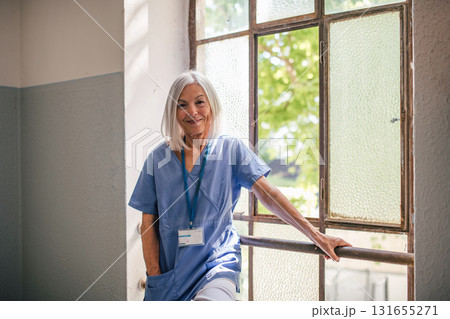 Tired nurse taking break, standing by old widnow. Tired nurse taking break, standing by old widnow. 131655271
