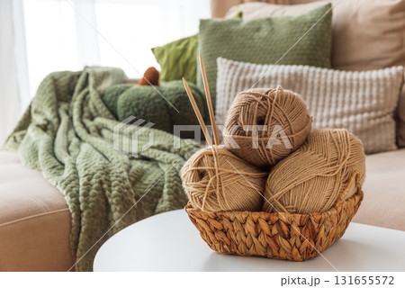 Basket with Yarn Balls on White Table in Cozy Living Room 131655572