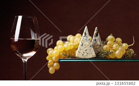 Glass of white wine with snacks. Grapes with blue cheese and thyme. Glass of white wine with snacks. Grapes with blue cheese and thyme. 131655802