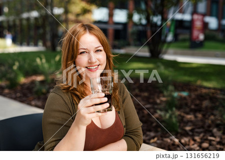 Plus size woman drinking soft soda drink outdoors. Plus size woman drinking soft soda drink outdoors. 131656219