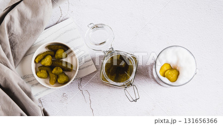 Picklatte with foam in a glass and pickles in a bowl on the table top view web banner 131656366