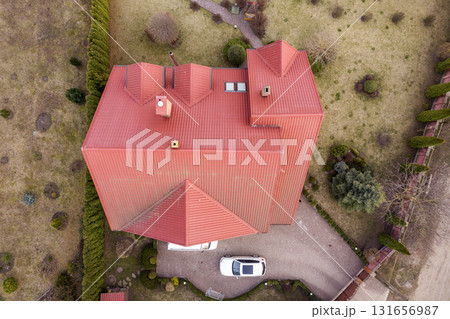 Aerial top view of new residential house cottage with shingle roof on fenced big yard on sunny day. Aerial top view of new residential house cottage with shingle roof on fenced big yard on sunny day. 131656987