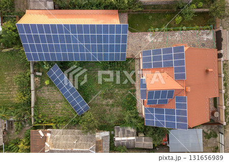 Aerial top view of new modern residential house cottage with blue shiny solar photo voltaic panels system on roof. Renewable ecological green energy production concept. 131656989
