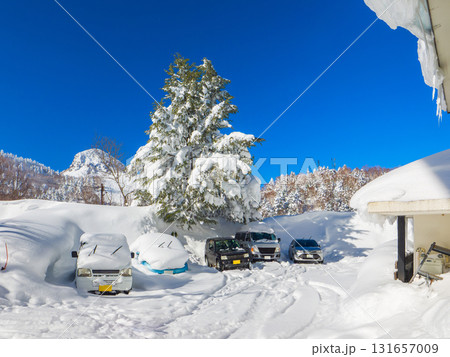 雪に覆われた車がある豪雪地帯の駐車場 (長野県、志賀高原) 131657009