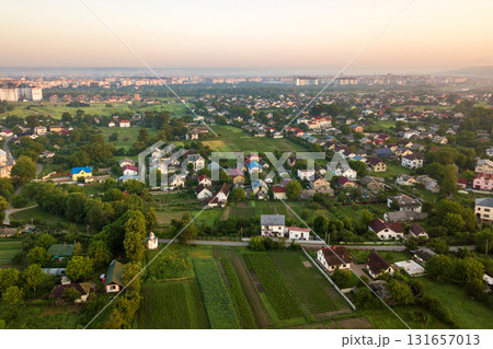 Aerial landscape of small town or village with rows of residential homes and green trees. 131657013