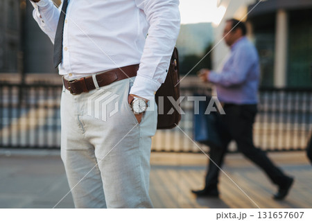 Businessman wearing wristwatch and formal clothes in city. 131657607