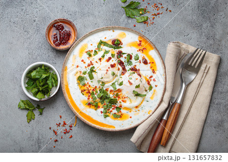 Turkish eggs cilbir, Middle Eastern style breakfast on grey concrete background table top view 131657832