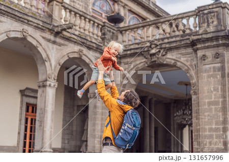 Father playfully tossing his young son in the air in front of Chapultepec Castle in Mexico City. Family travel, cultural heritage, joy, and bonding moment 131657996