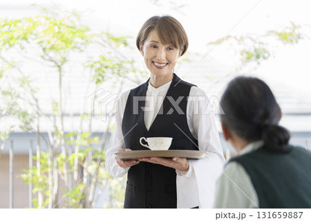 カフェの女性スタッフとシニア男性 131659887