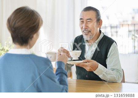 向かい合ってお茶を飲むシニアの男女 131659888
