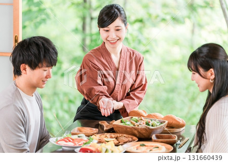 温泉旅館の客室で料理の説明をする旅館スタッフ・仲居さんの女性 温泉旅館の客室で料理の説明をする旅館スタッフ・仲居さんの女性 131660439