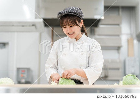 厨房でキャベツを切る調理スタッフの女性 131660765