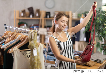 Young women choosing handbag in store Young women choosing handbag in store 131661574