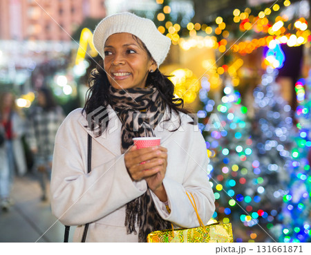 Positive Latin American woman stands with a paper cup Positive Latin American woman stands with a paper cup 131661871