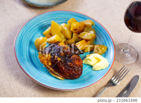Baked chicken piece and potato in the plate 131661886
